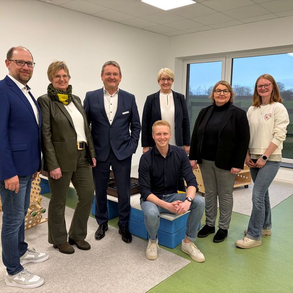 Sieben Personen stehen für ein Pressefoto im Bewegungsraum der KSB-Kita in Tudorf.